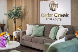Sign and couch in lobby at Cedar Creek Post Acute