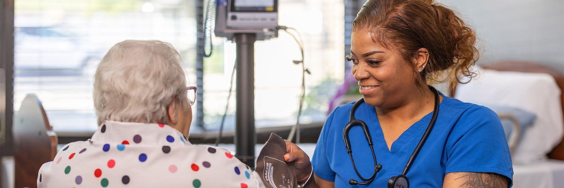 Nurse taking patient's blood pressure at Cedar Creek Post Acute